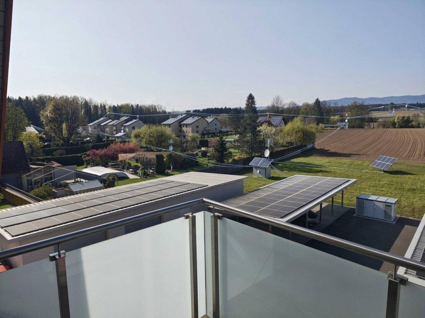 Panoramablick vom Balkon über die Dächer der Nachbarschaft und weite Felder.