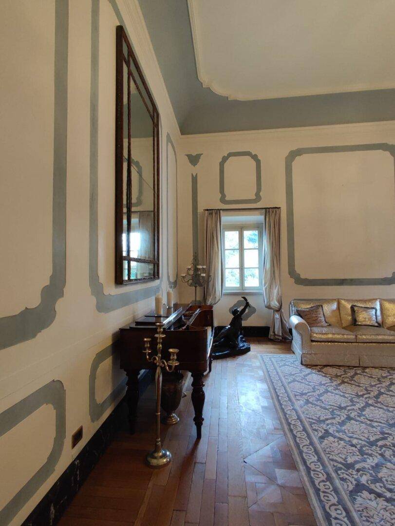 Elegantes Wohnzimmer mit Fischgrätparkett, großem Spiegel und klassischer Einrichtung, die den historischen Charme bewahrt.