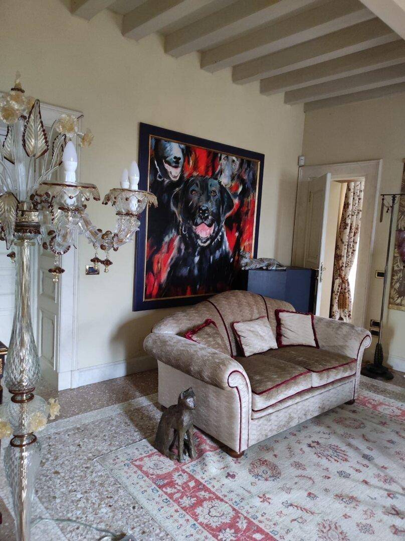 Helles Wohnzimmer mit Terrazzoboden, Sofa und einem auffälligen Hundegemälde, das Persönlichkeit verleiht.