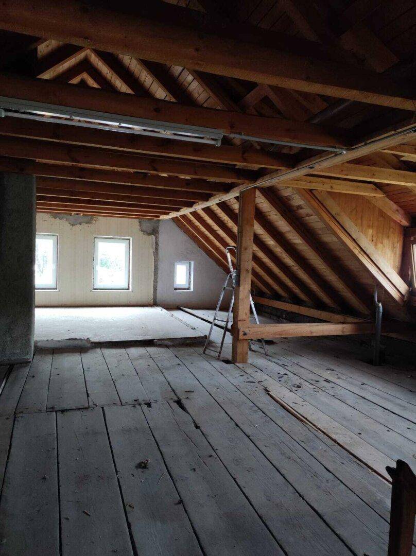Unausgebauter Dachboden mit Holzdielenboden und sichtbarer Dachkonstruktion, viel Potenzial.