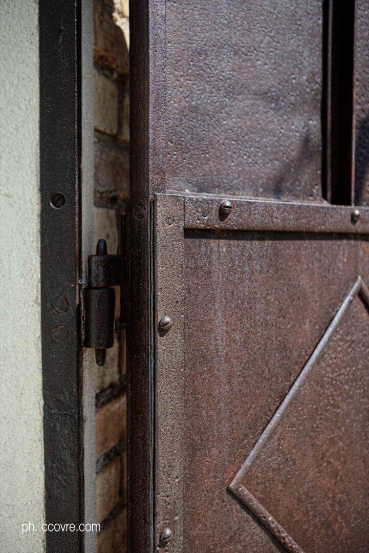 Nahaufnahme eines rostigen Metallscharniers an einer Tür oder einem Fensterladen.
