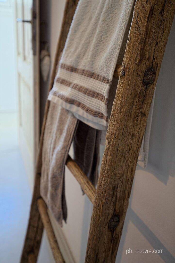 Nahaufnahme eines rustikalen Holzleiters als Handtuchhalter im Badezimmer.