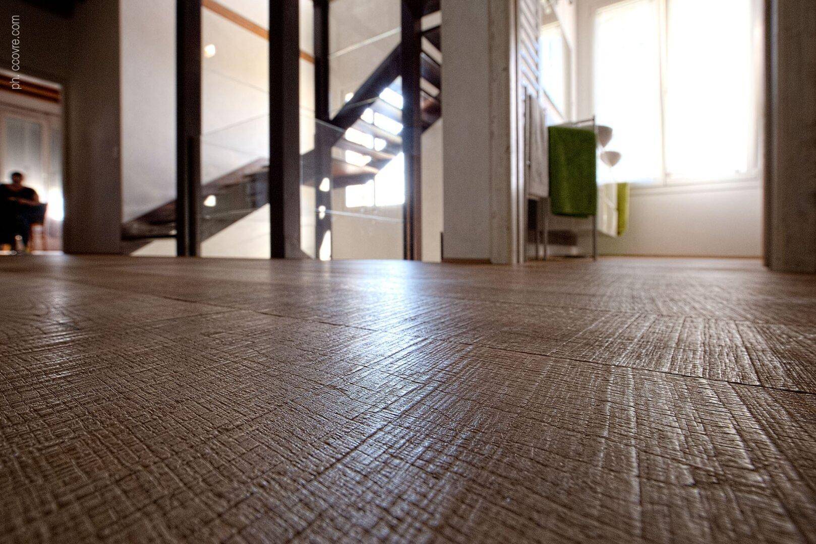 Nahaufnahme eines strukturierten Holzbodens, der das natürliche Licht reflektiert.