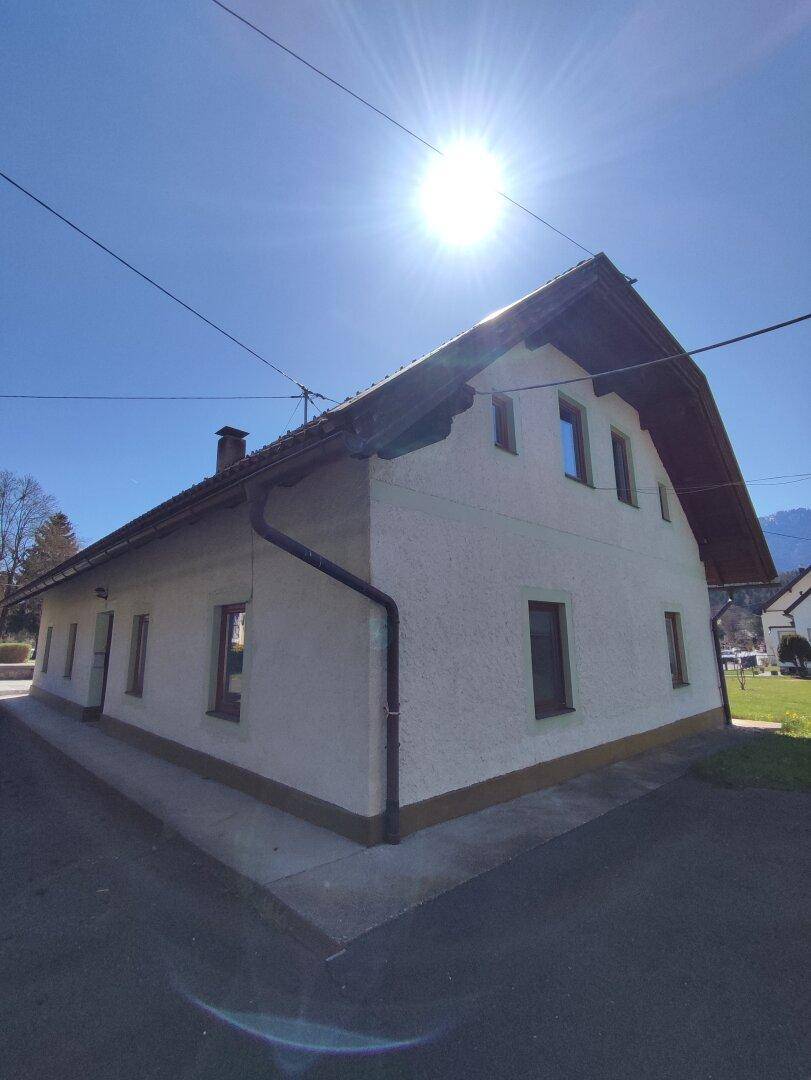 Hausfassade mit Satteldach und Fenstern, beleuchtet von der tiefstehenden Sonne am Nachmittag.