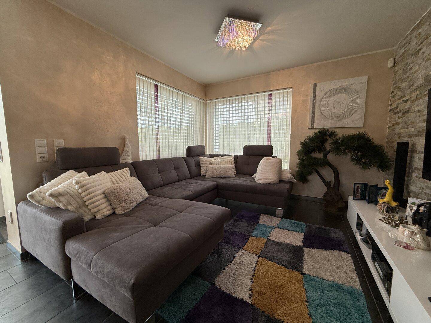 Gemütliches Wohnzimmer mit großem Ecksofa, modernem Teppich und stilvoller Dekoration.