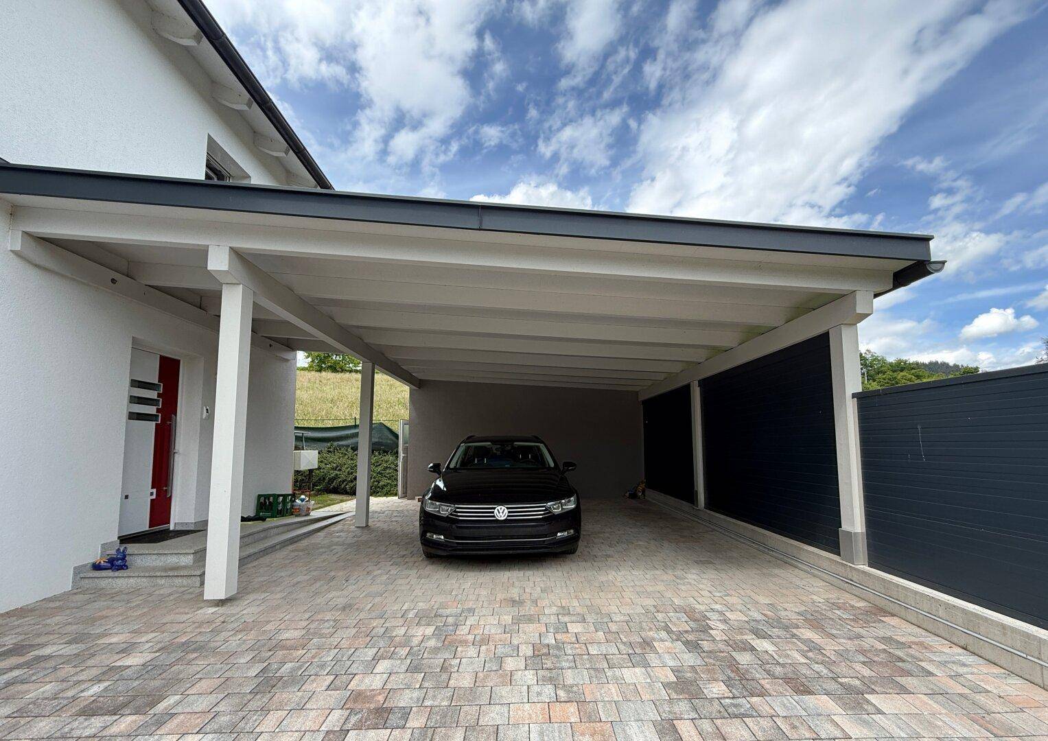 Geräumiger Carport mit Platz für ein Fahrzeug und direkter Zugang zum Haus.