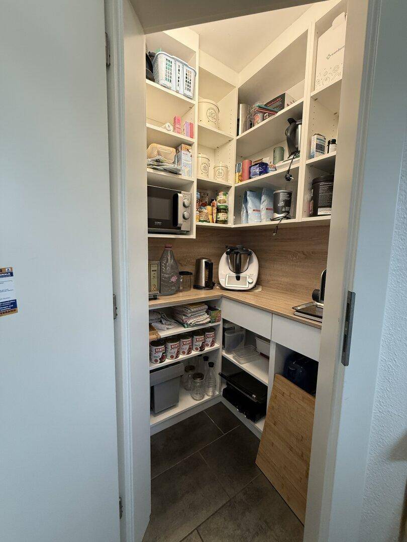 Praktische Speisekammer mit vielen Regalen für Vorräte und Küchengeräte.