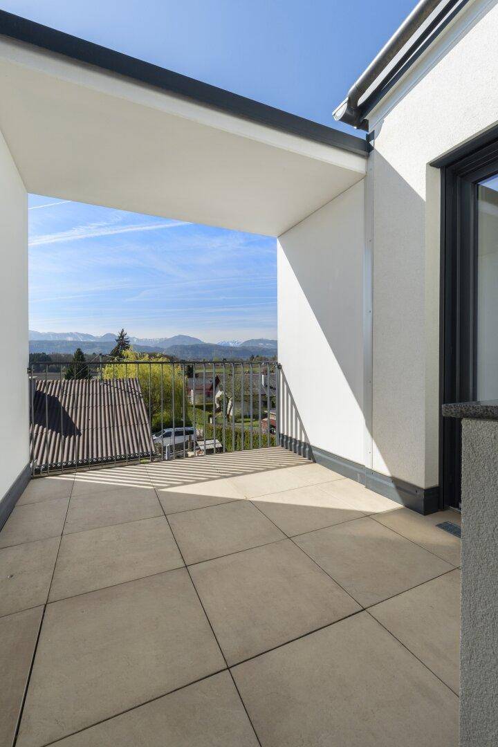 Großer Balkon mit Fliesenboden und einer beeindruckenden Aussicht auf die Berge.