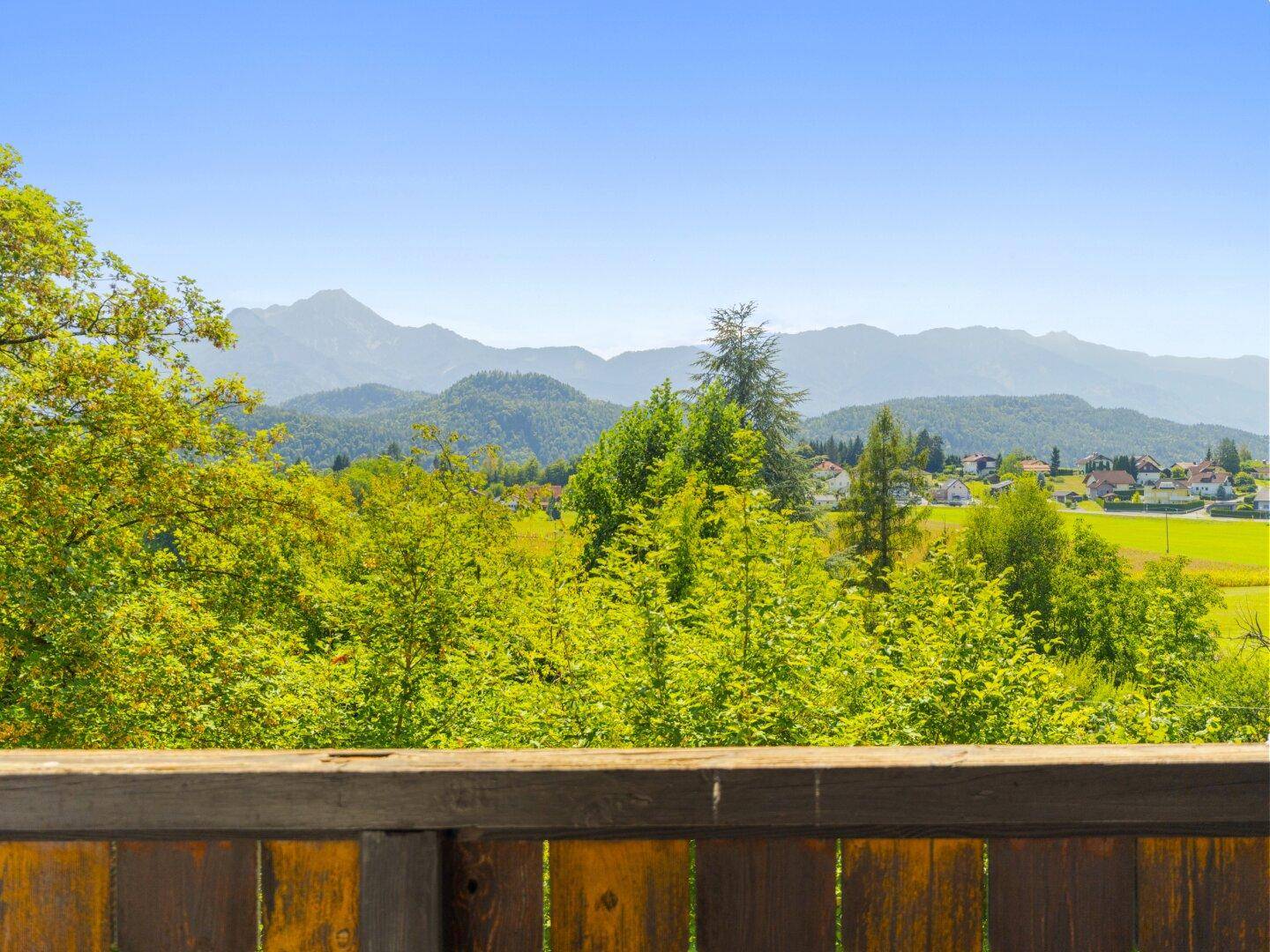Malerischer Ausblick von der Terrasse auf die grüne Landschaft und die fernen Berge.