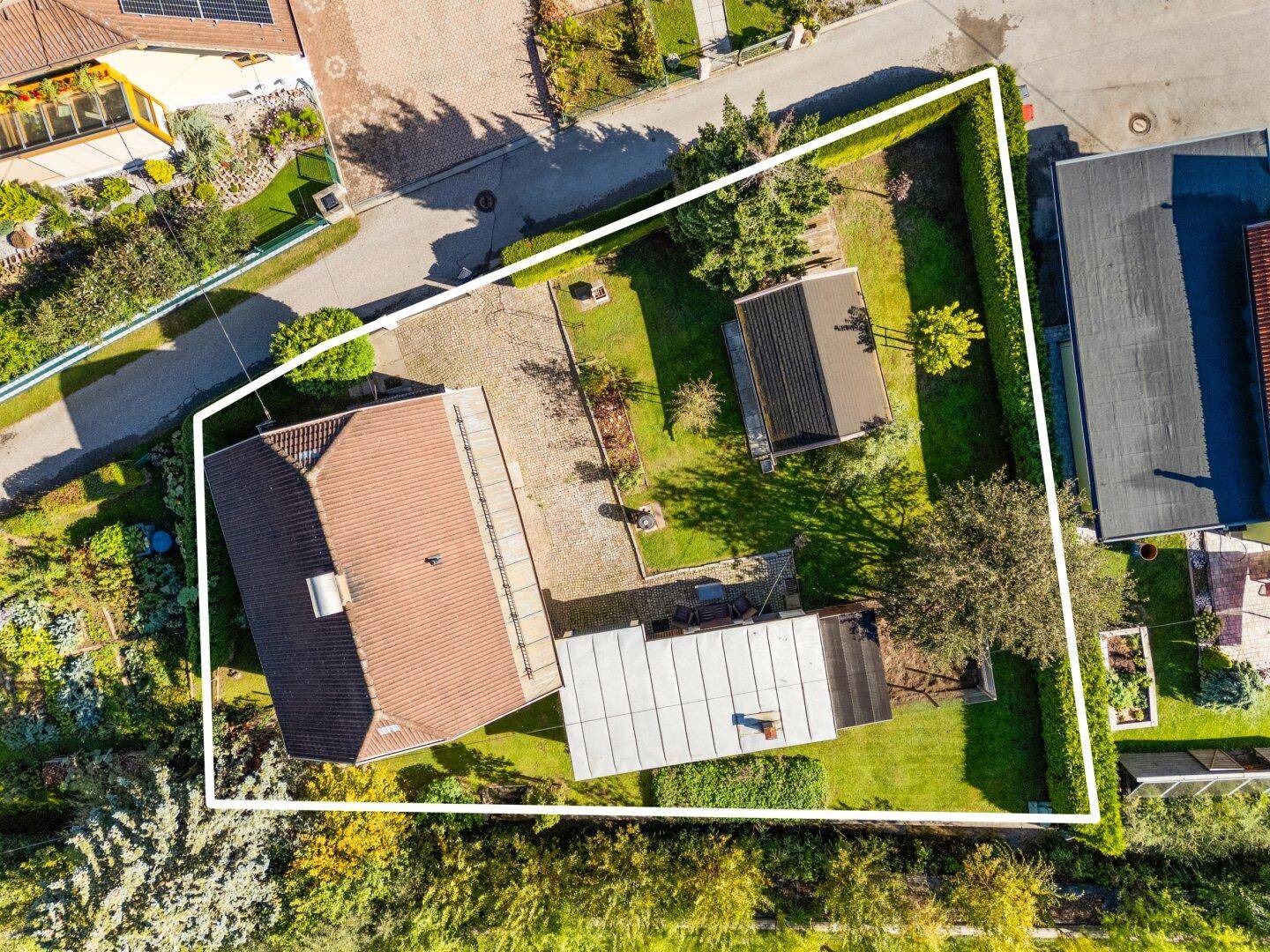 Detaillierte Luftaufnahme des Grundstücks mit Haus, Nebengebäuden und Gartenfläche.
