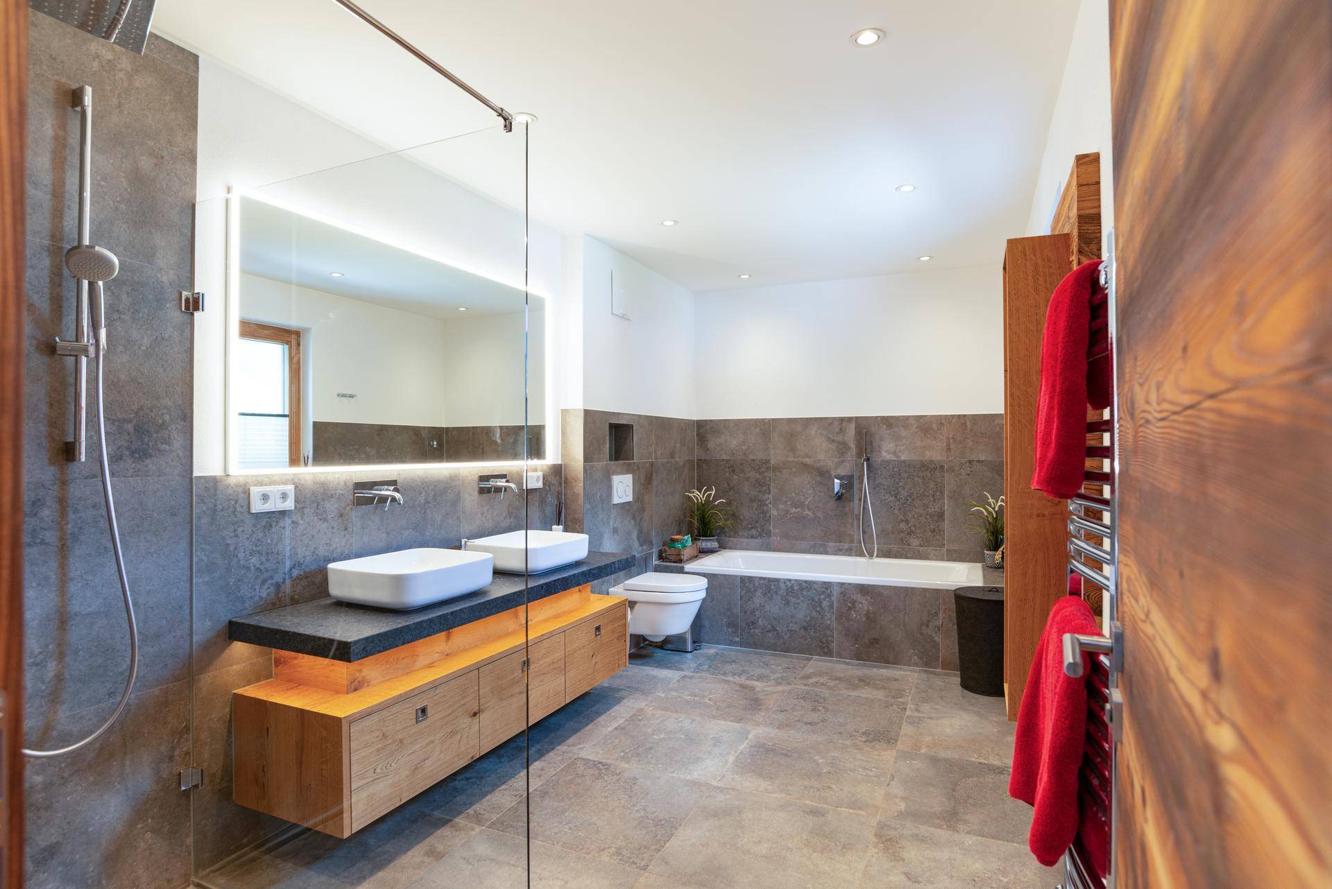 Modernes Badezimmer mit Doppelwaschbecken, großer Dusche und Badewanne.