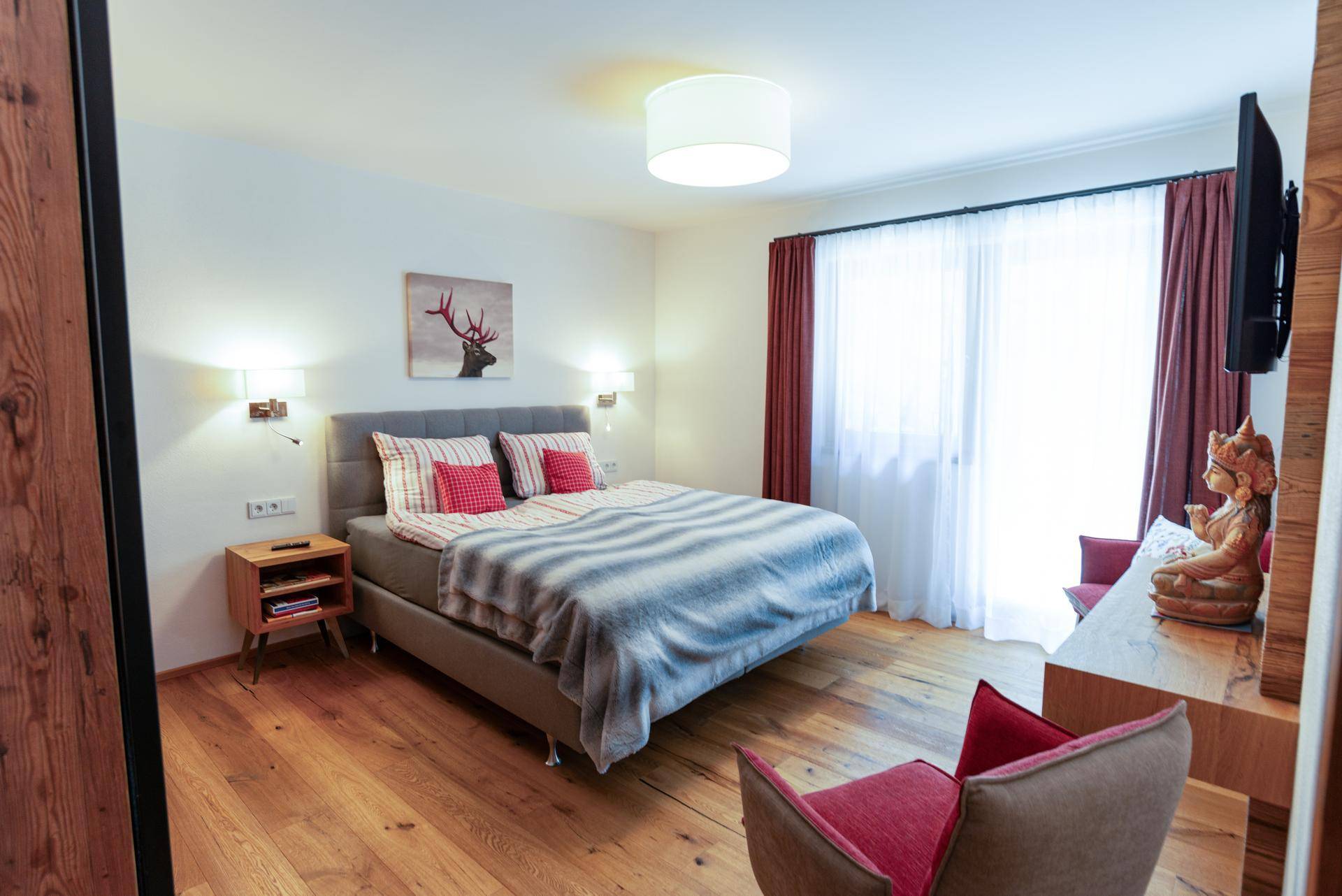 Komfortables Schlafzimmer mit Holzboden, Doppelbett und moderner Einrichtung.