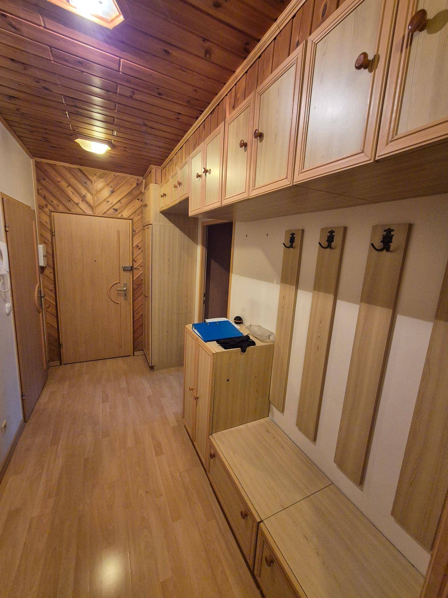 Eingangsbereich mit Holzvertäfelung, Einbauschränken und Garderobe, die viel Stauraum bieten.