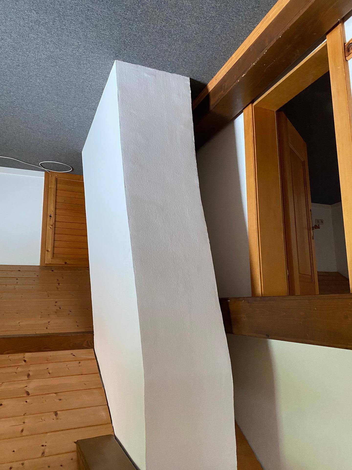 Innenansicht mit weißer Wandstruktur und Holzelementen.