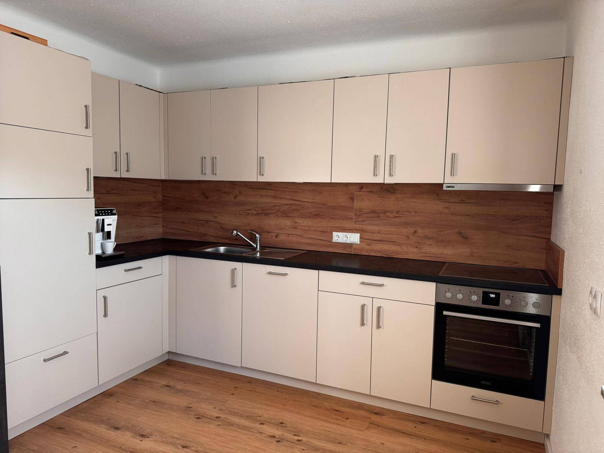 Helle Einbauküche mit integrierten Geräten und funktionalem Design.