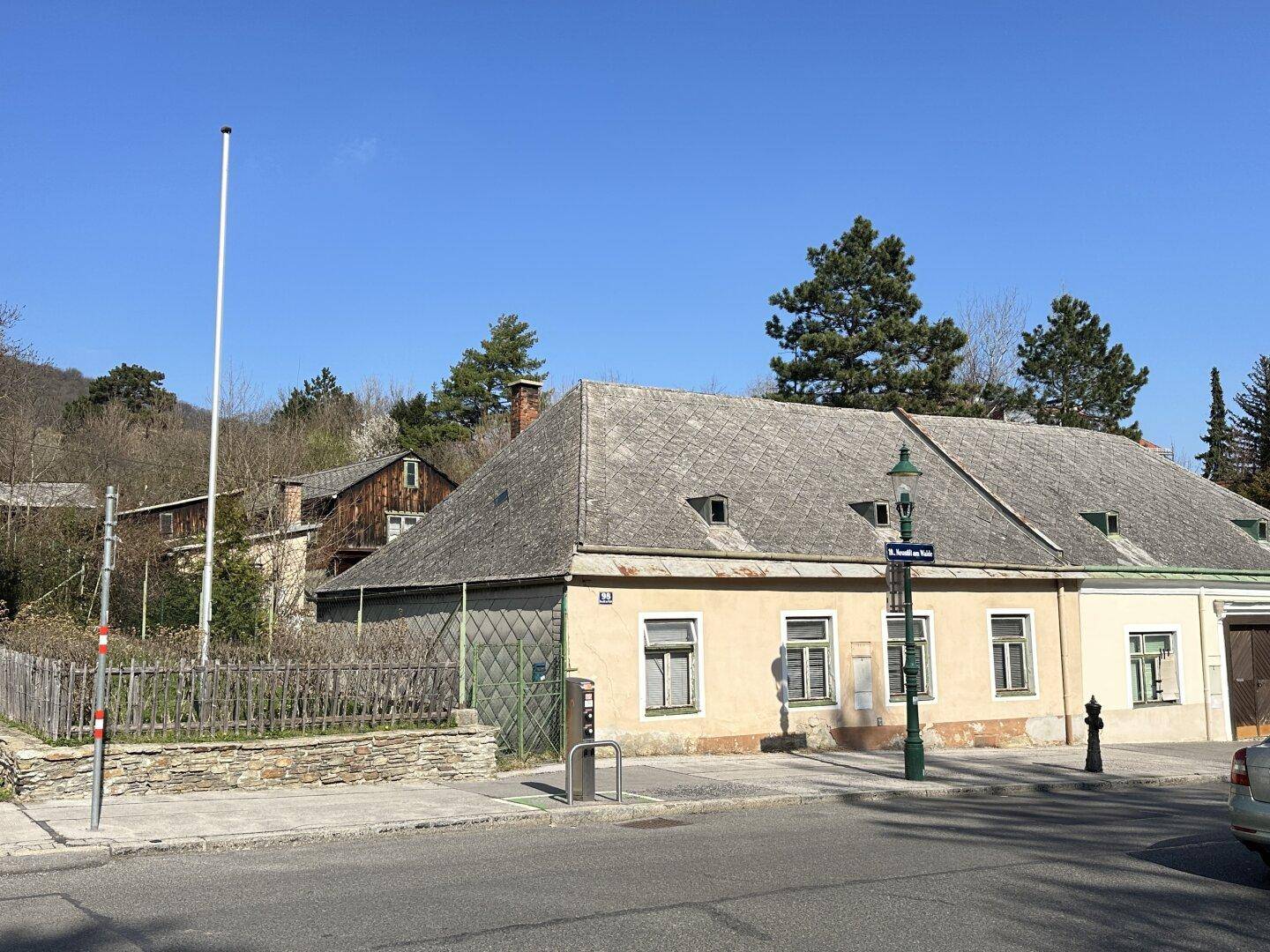 Historisches Gebäude mit traditioneller Fassade und Satteldach an einer ruhigen Straße gelegen.