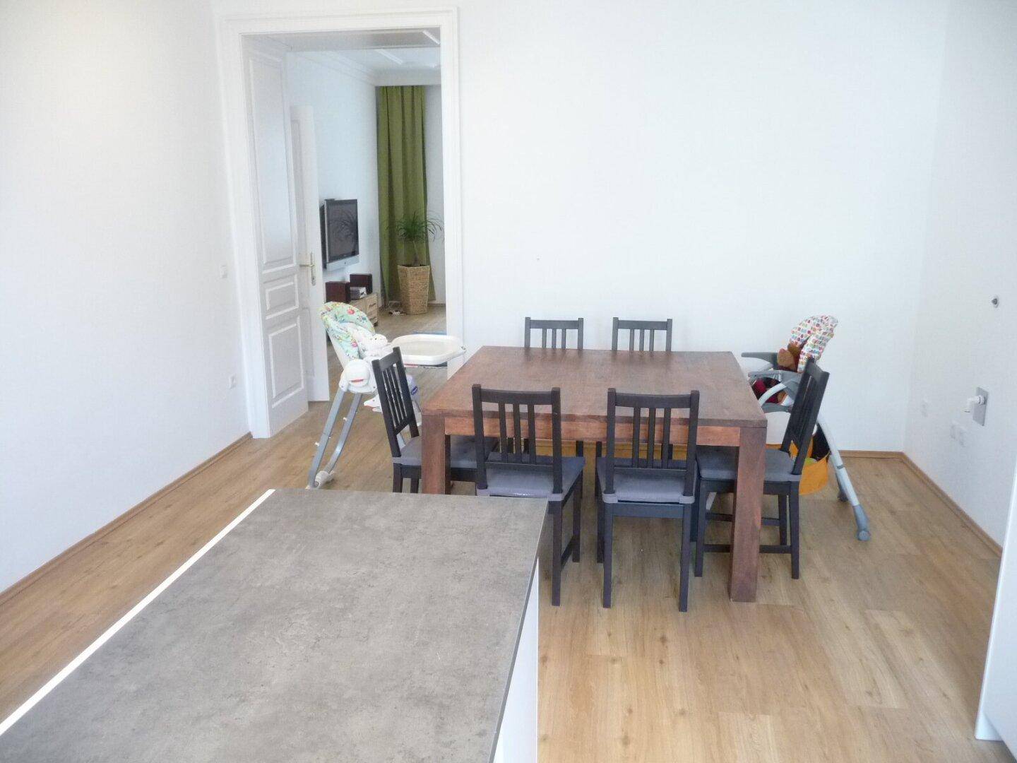 Geräumiger Essbereich mit großem Holztisch und Zugang zu einem weiteren Zimmer.