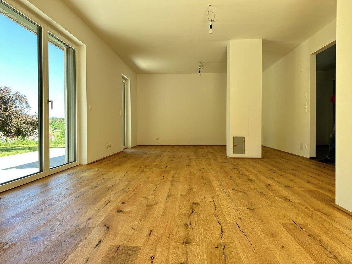 Geräumiger Wohnbereich mit Eichenparkett und großen Fensterfronten für viel Tageslicht.