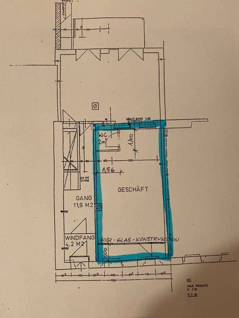 Grundrissplan eines Geschäftsraums mit WC, Windfang und Gang, hervorgehoben durch eine Holz-Glas-Konstruktion.