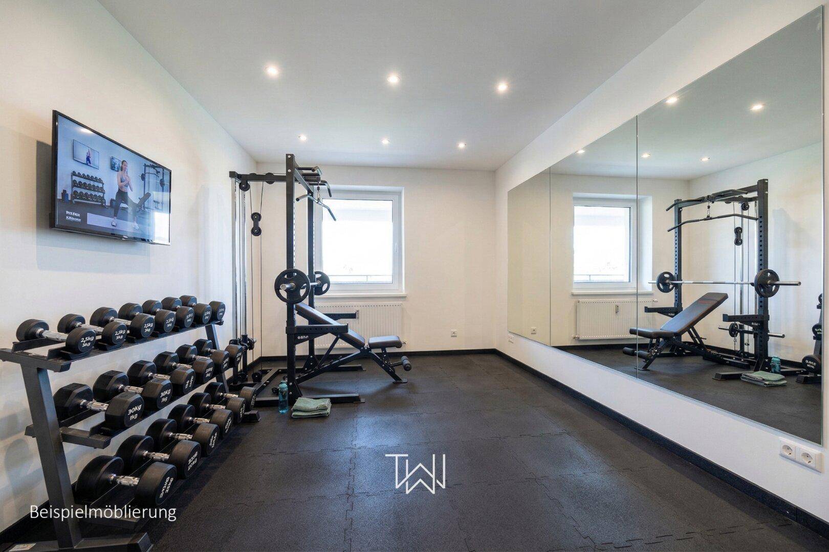 Gut ausgestatteter Fitnessraum mit Hanteln, Trainingsbank und großen Spiegeln.