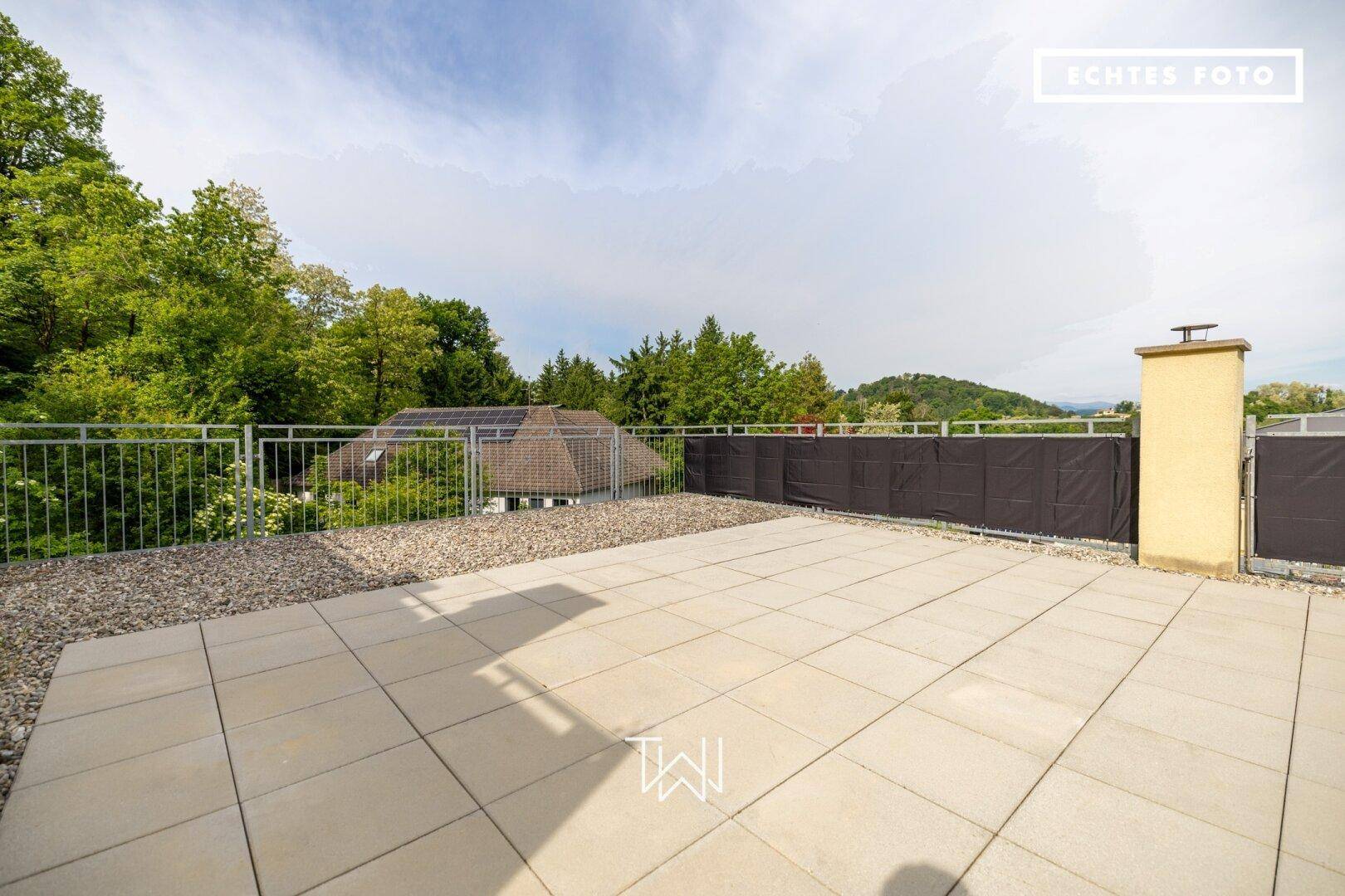 Weitläufige Dachterrasse mit Kiesbereich und Fliesen, bietet viel Platz für individuelle Gestaltung.
