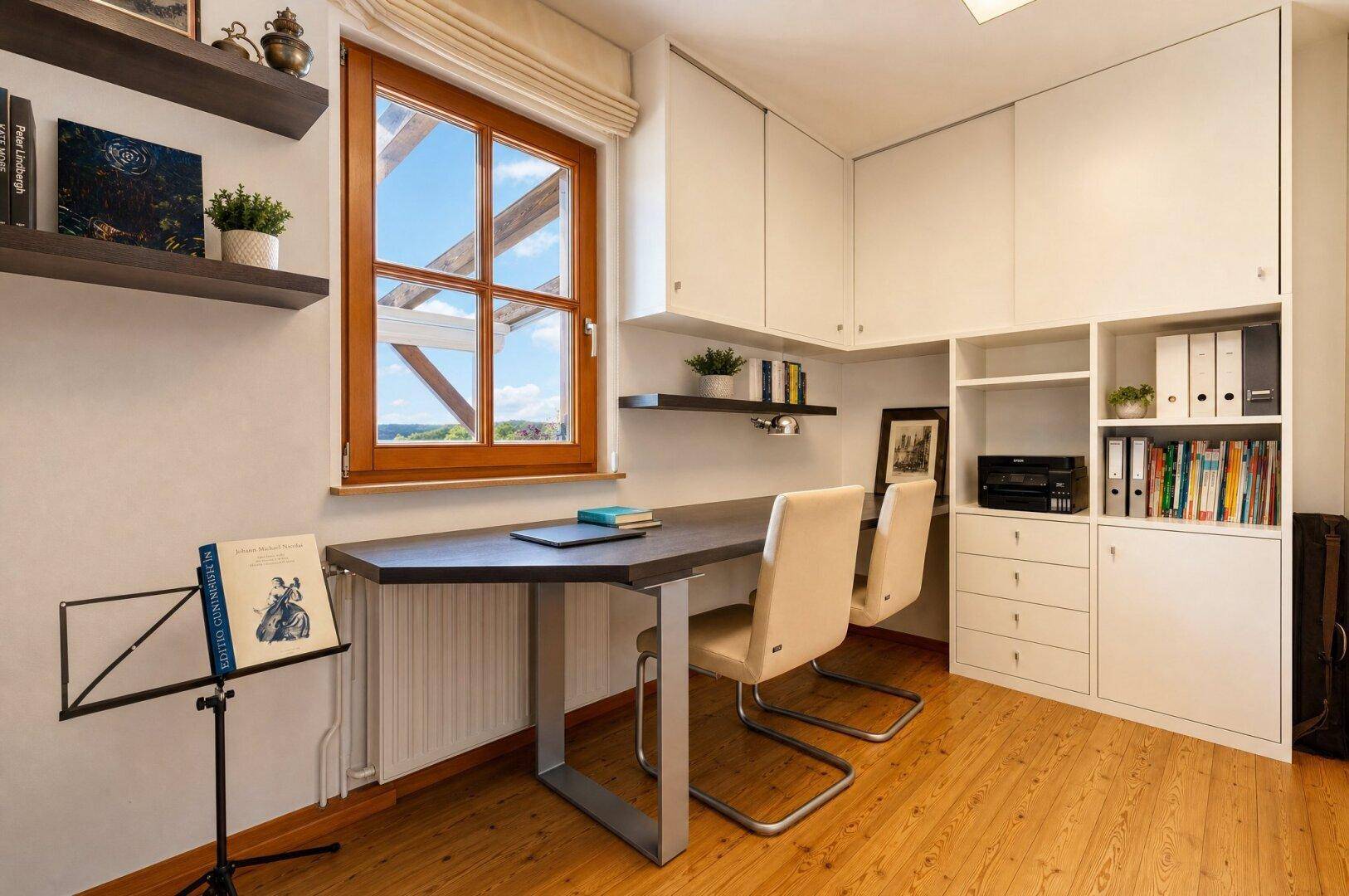 Funktionales Arbeitszimmer mit Holzboden, Einbauschränken und großem Fenster mit Ausblick.