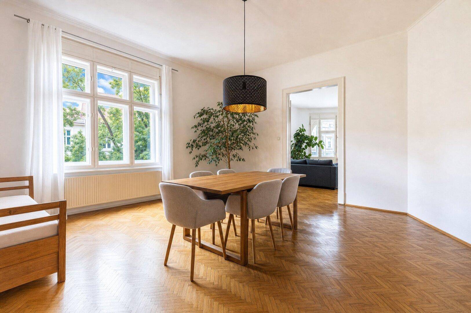 Geräumiger Essbereich mit Holztisch, modernen Stühlen und Fischgrätparkett.