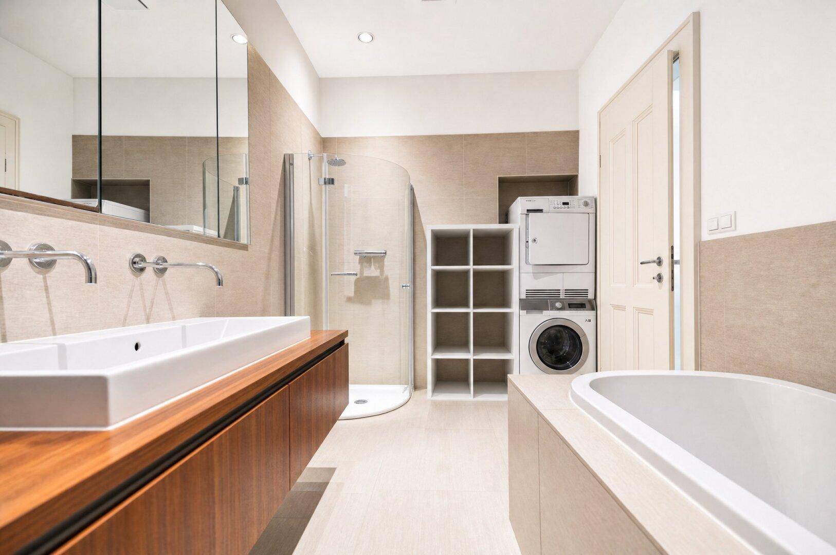 Geräumiges Badezimmer mit Dusche, Badewanne, Doppelwaschbecken und Waschmaschine.
