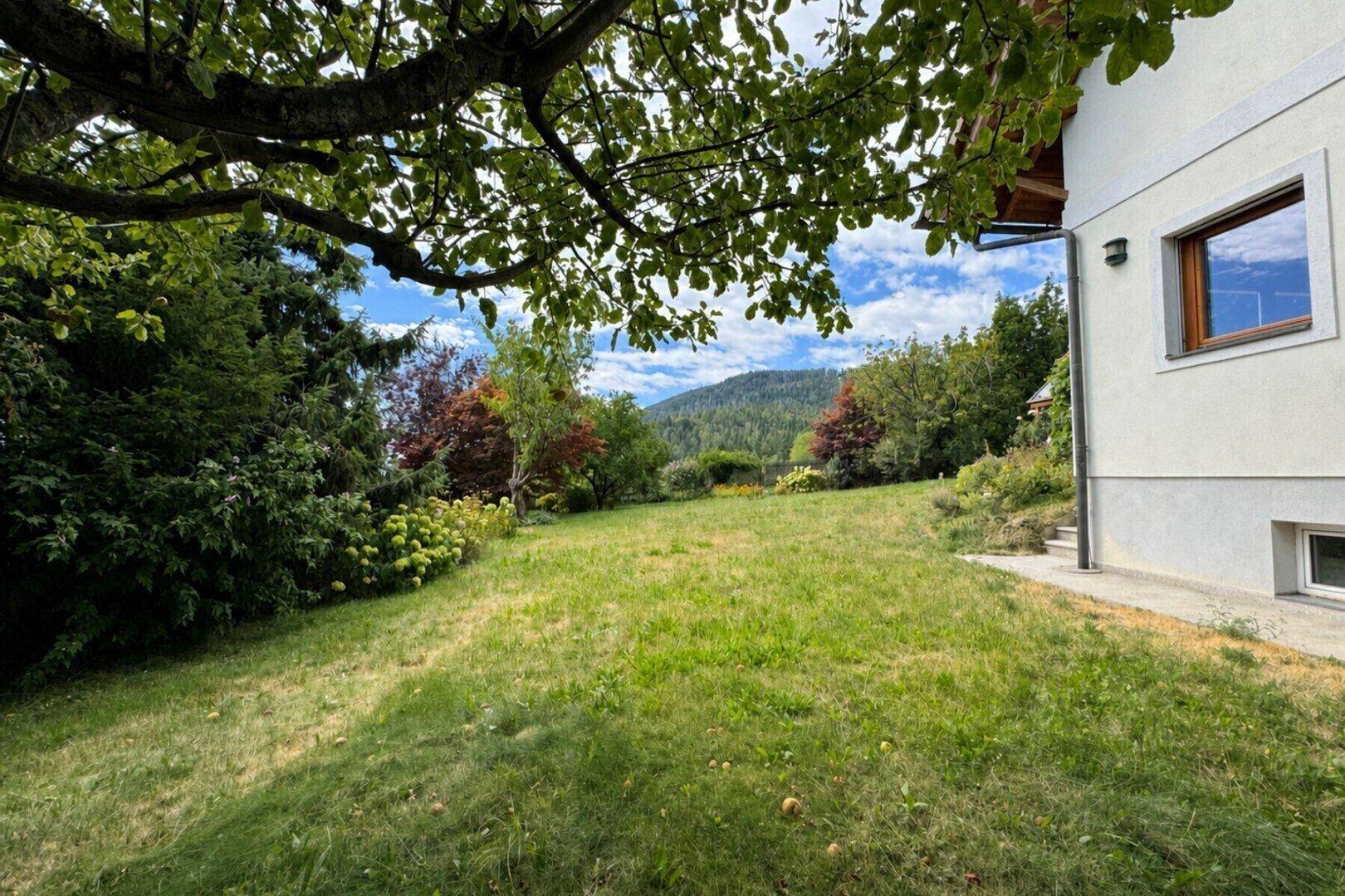 Großer, gepflegter Gartenbereich mit Rasenfläche und Blick auf die umliegende Hügellandschaft.