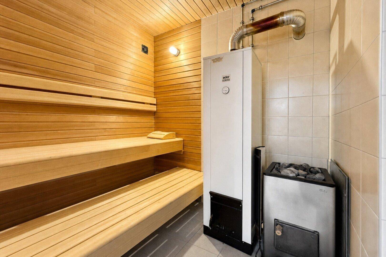 Gemütliche Sauna mit Holzverkleidung und traditionellem Saunaofen für Entspannung.