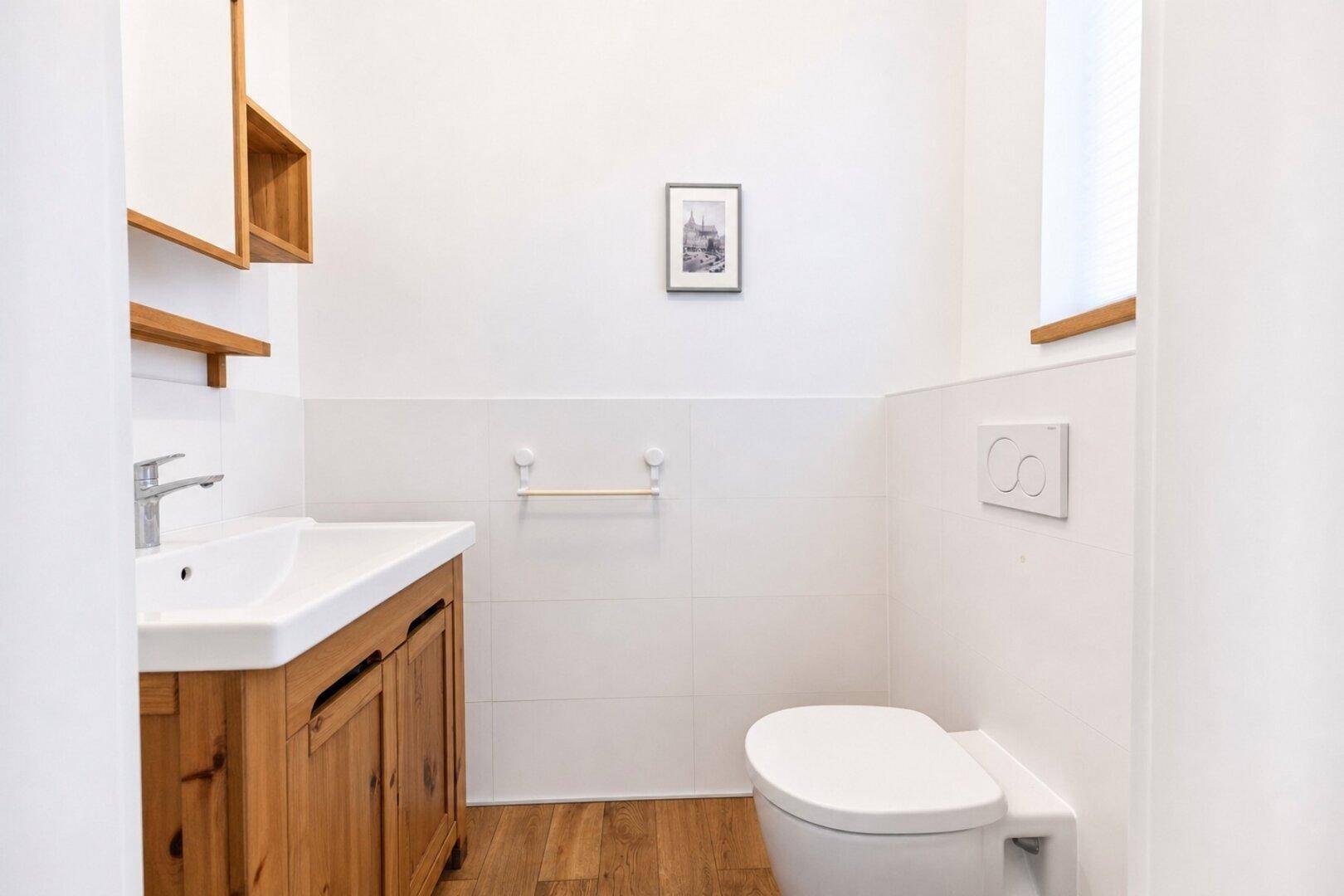 Helles Gäste-WC mit modernem Waschtisch, Wand-WC und Holzdetails.