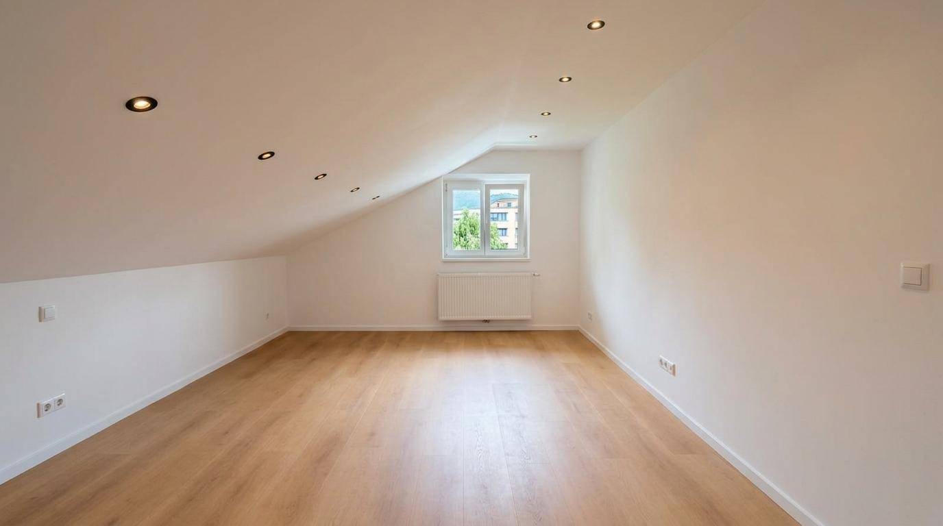 Lichtdurchflutetes Dachzimmer mit Holzboden und Ausblick ins Grüne, perfekt für Ruhe und Entspannung.