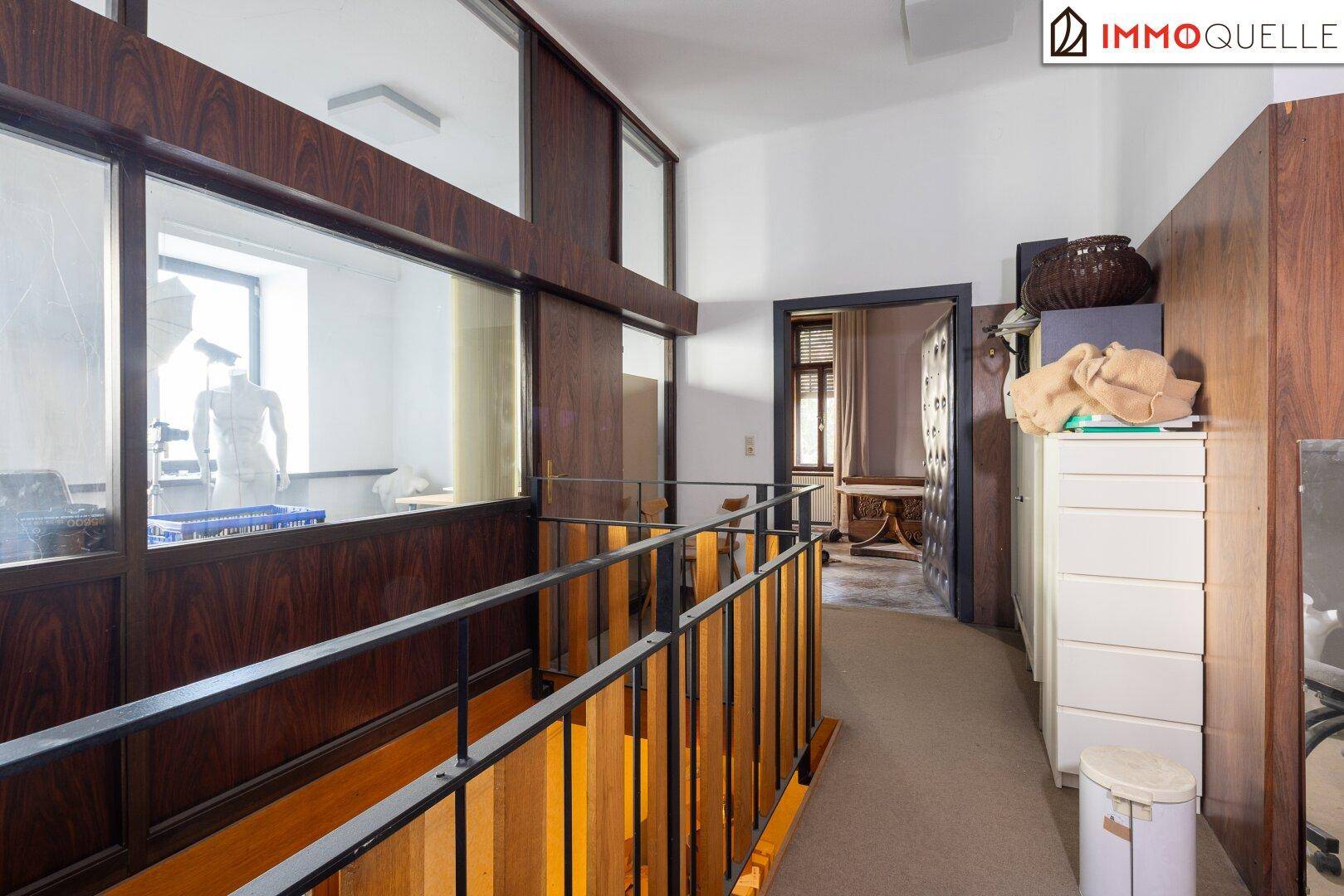Heller Flur im Obergeschoss mit Holzvertäfelung und Blick in den unteren Bereich des Hauses.