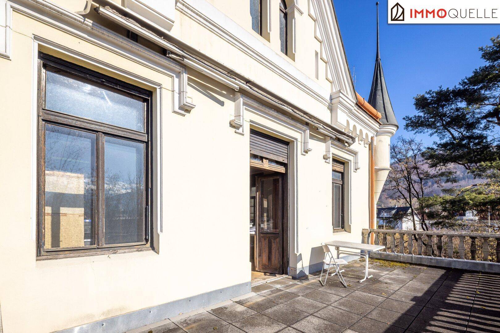 Geräumige Terrasse mit Zugang zum Gebäude und Panoramablick auf die Natur.