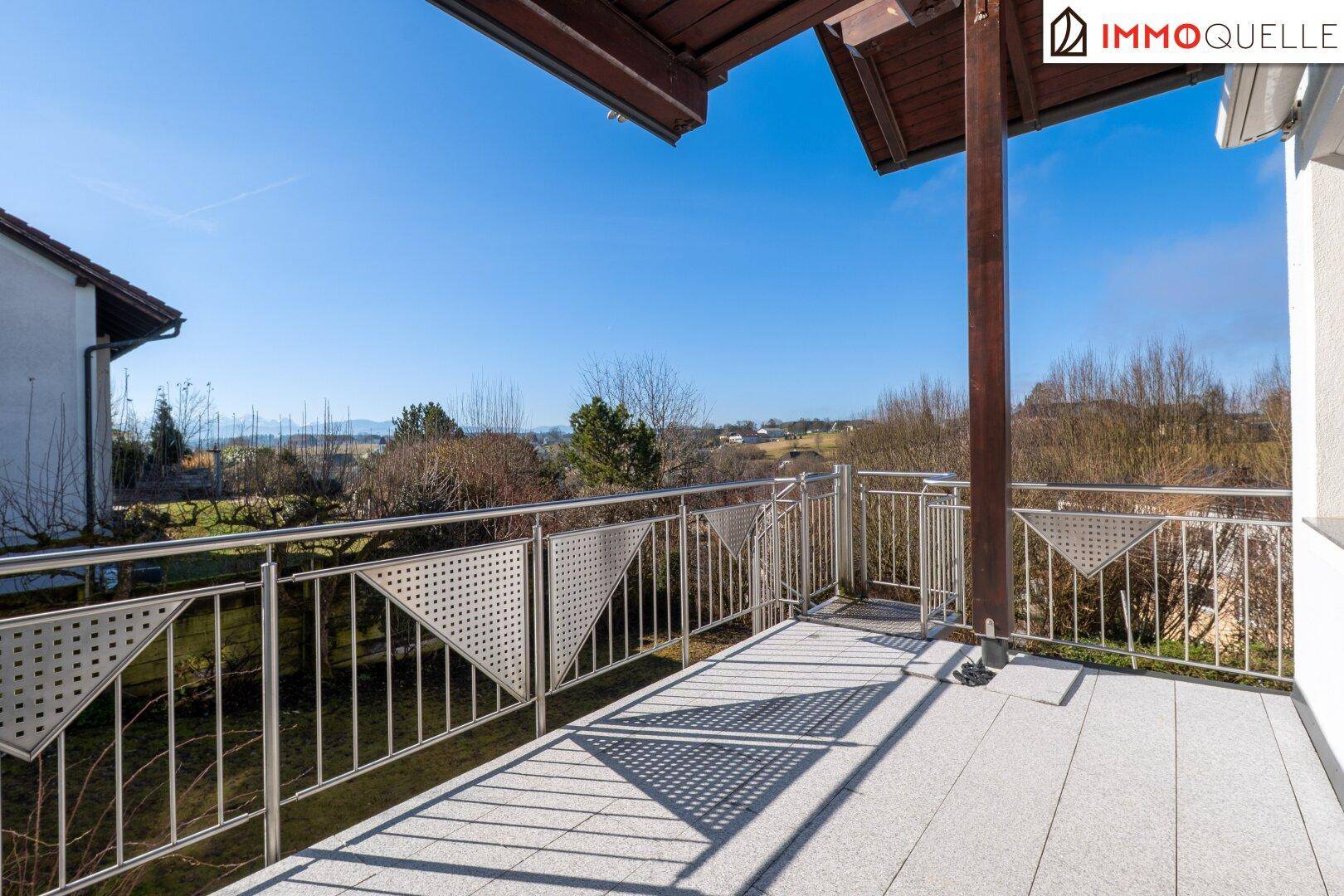 Großer Balkon mit Metallgeländer und weitem Blick über die Landschaft.