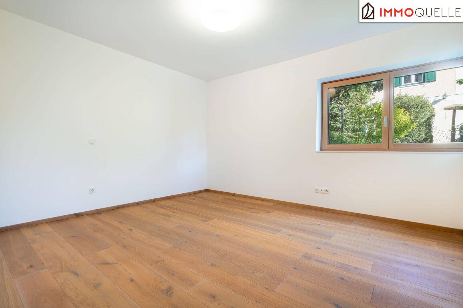 Helles Zimmer mit Holzboden und Fenster, ideal als Schlaf- oder Gästezimmer.
