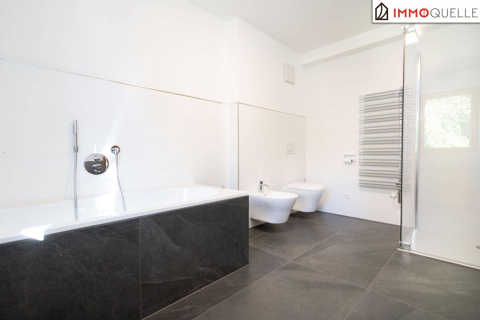 Geräumiges Badezimmer mit Badewanne, Dusche, Bidet und beheiztem Handtuchhalter.
