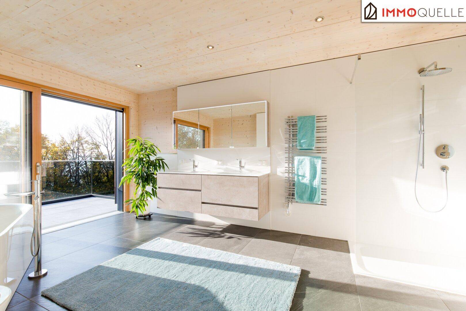 Elegantes Badezimmer mit Doppelwaschbecken, großer Dusche und beheiztem Handtuchhalter.
