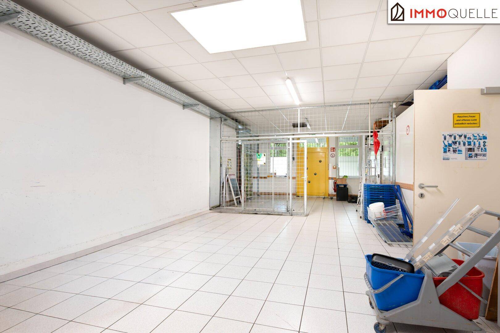 Geräumiger Lagerbereich mit Fliesenboden und einem Gitterkäfig, ideal für die sichere Aufbewahrung von Waren.