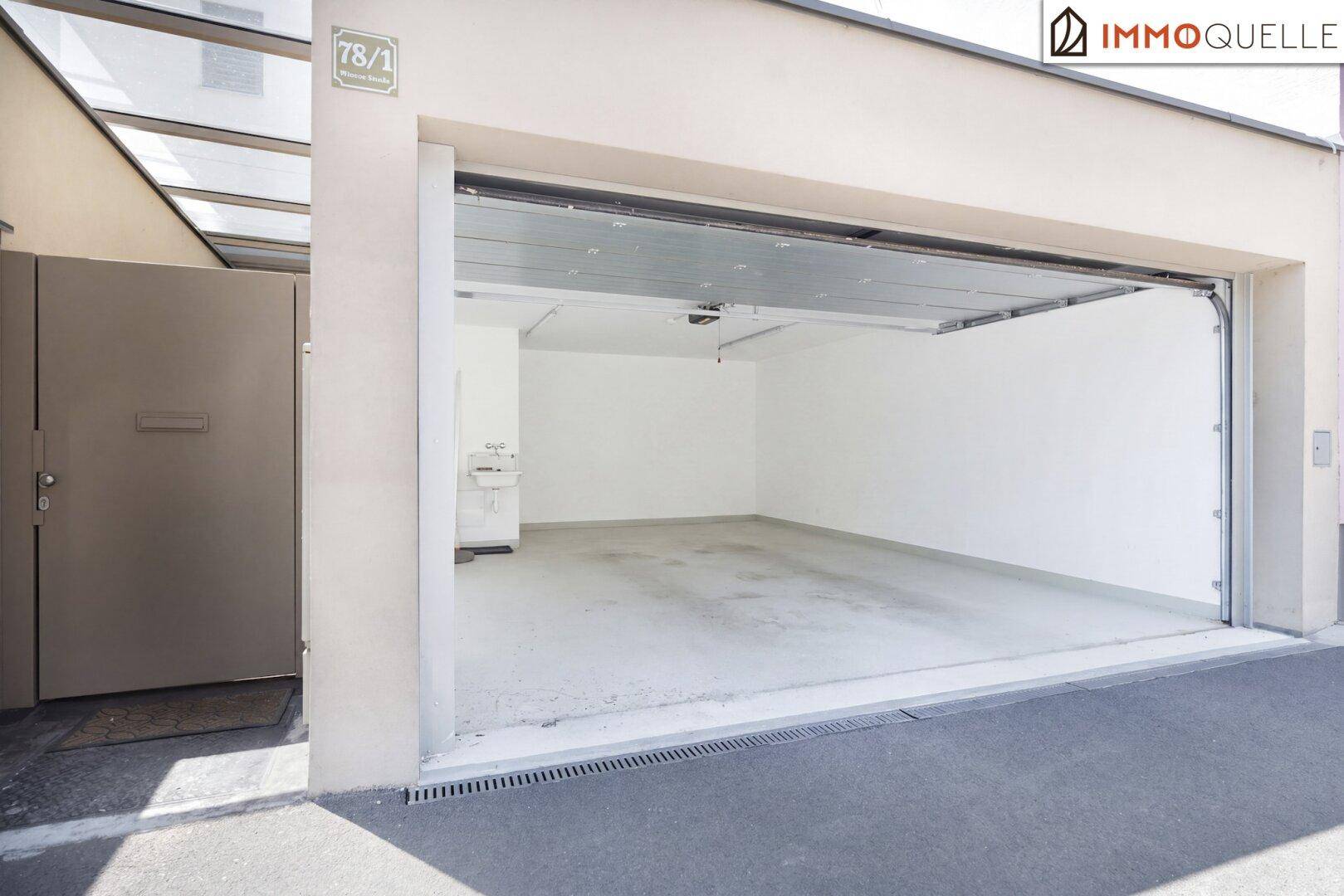Geräumige Doppelgarage mit offenem Tor und sauberem Betonboden.