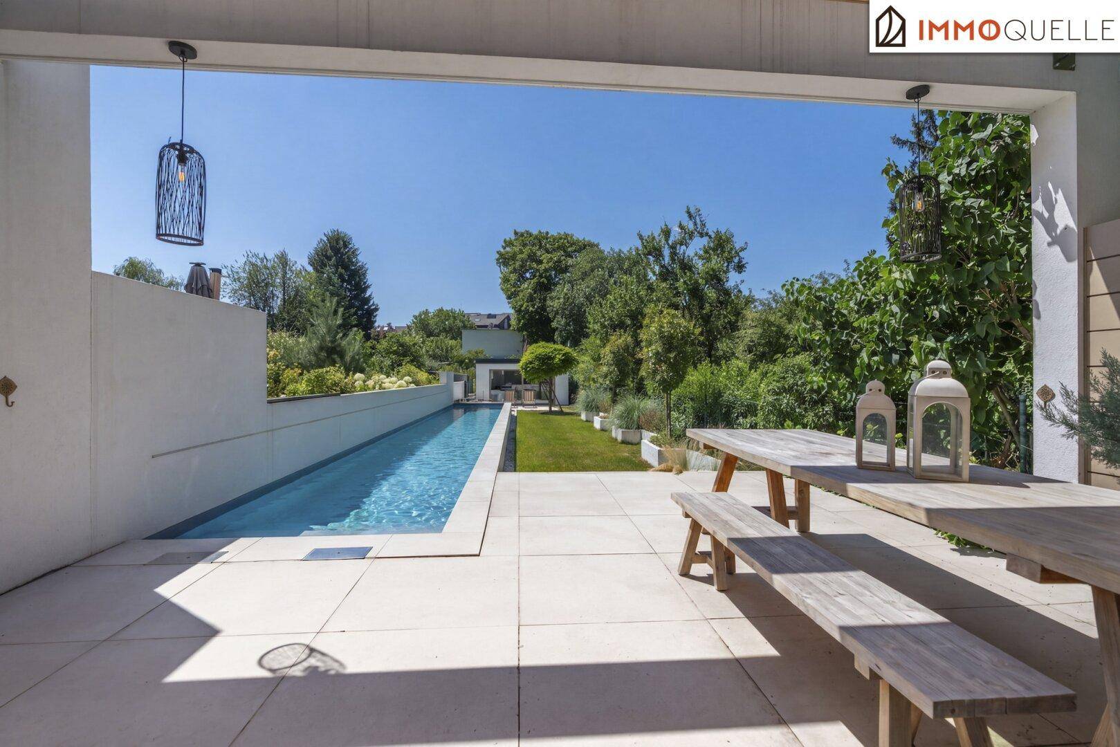 Geräumige, überdachte Terrasse mit rustikalen Holzmöbeln und Blick auf den Pool und Garten.
