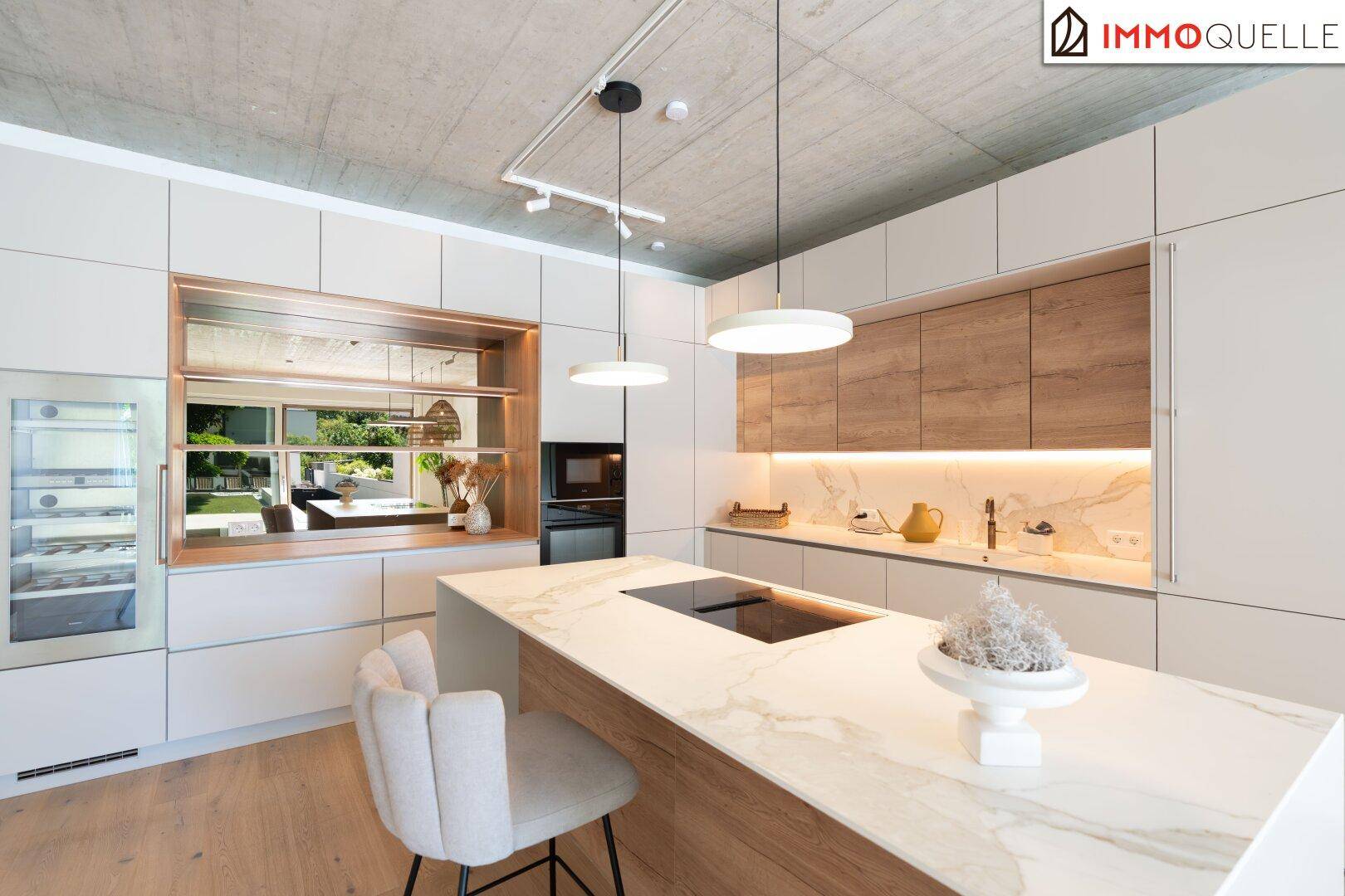 Elegante, moderne Küche mit Kochinsel, Marmorarbeitsplatte und integrierten Geräten.