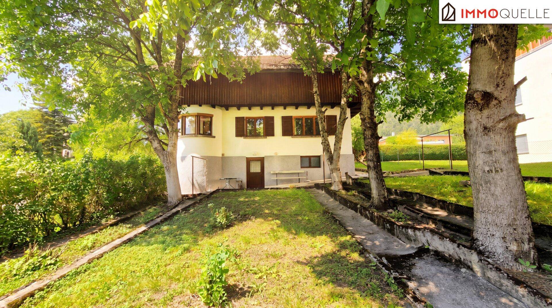 Rückseite des Hauses mit Gartenbereich und altem Baumbestand.