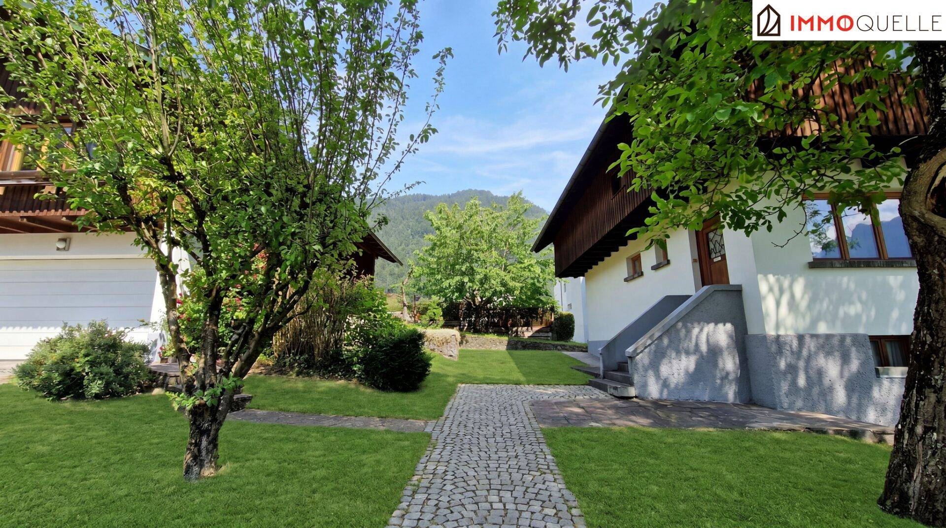 Steinweg durch den gepflegten Garten, der zum Haus führt.
