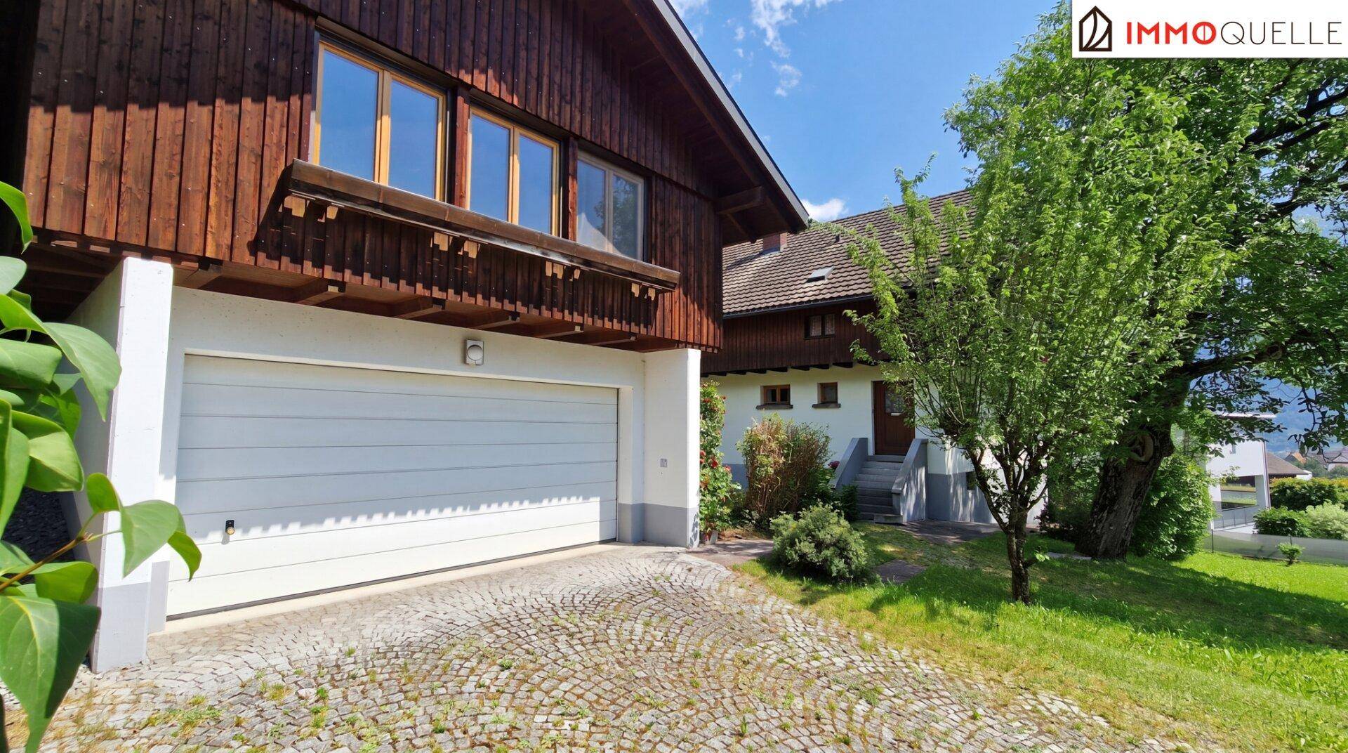 Einfahrt zur Garage mit Kopfsteinpflaster und Blick auf die Hausfassade.