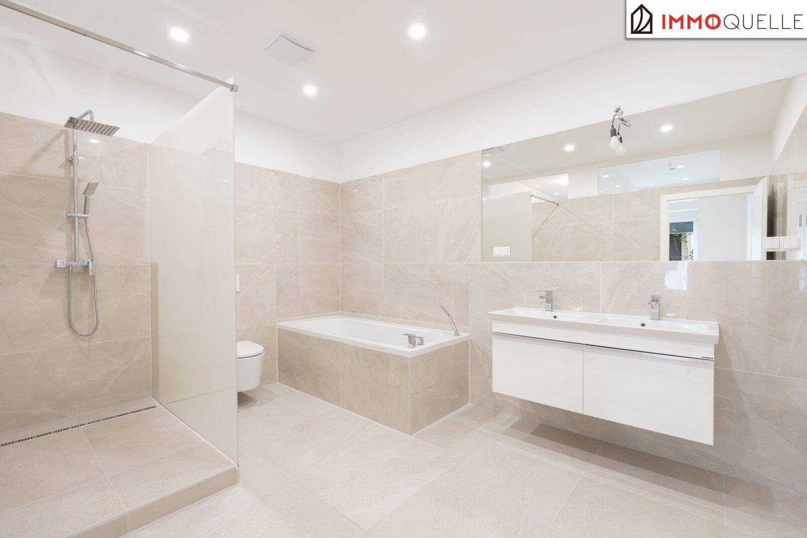 Geräumiges, modernes Badezimmer mit Doppelwaschbecken, begehbarer Dusche, Badewanne und hellen Fliesen.