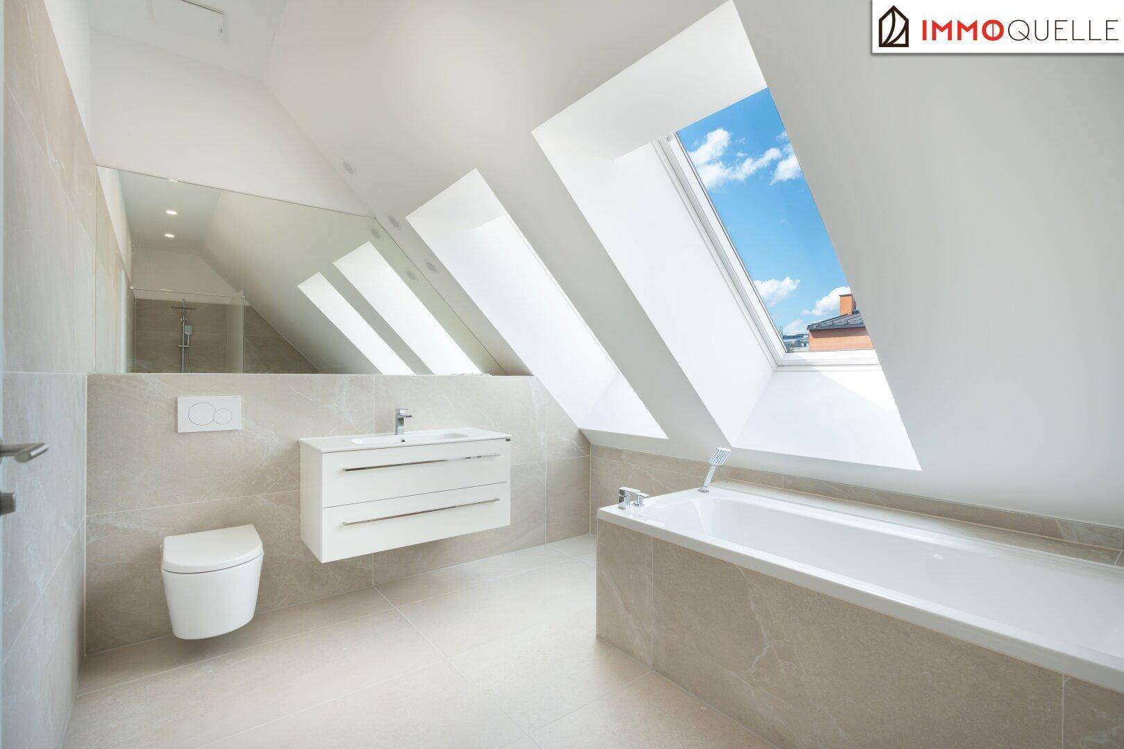Modernes Badezimmer mit Badewanne, schwebendem Waschtisch und Dachfenstern.
