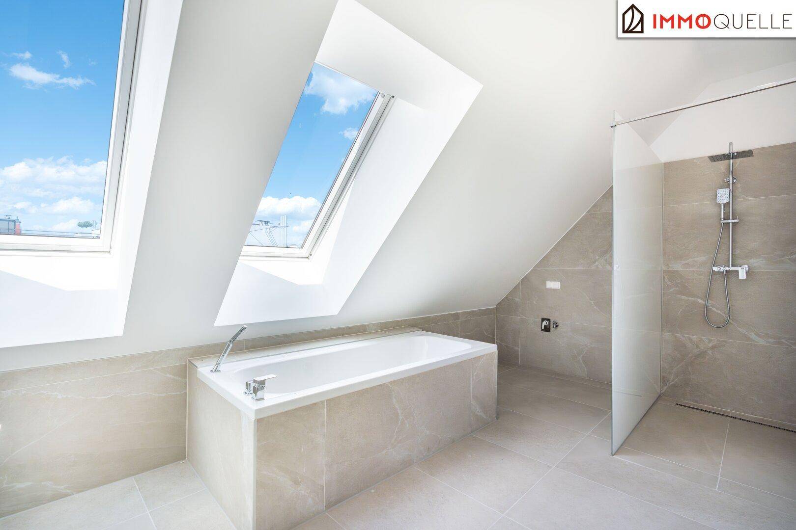 Helles Badezimmer mit Badewanne, begehbarer Dusche und Dachfenstern.