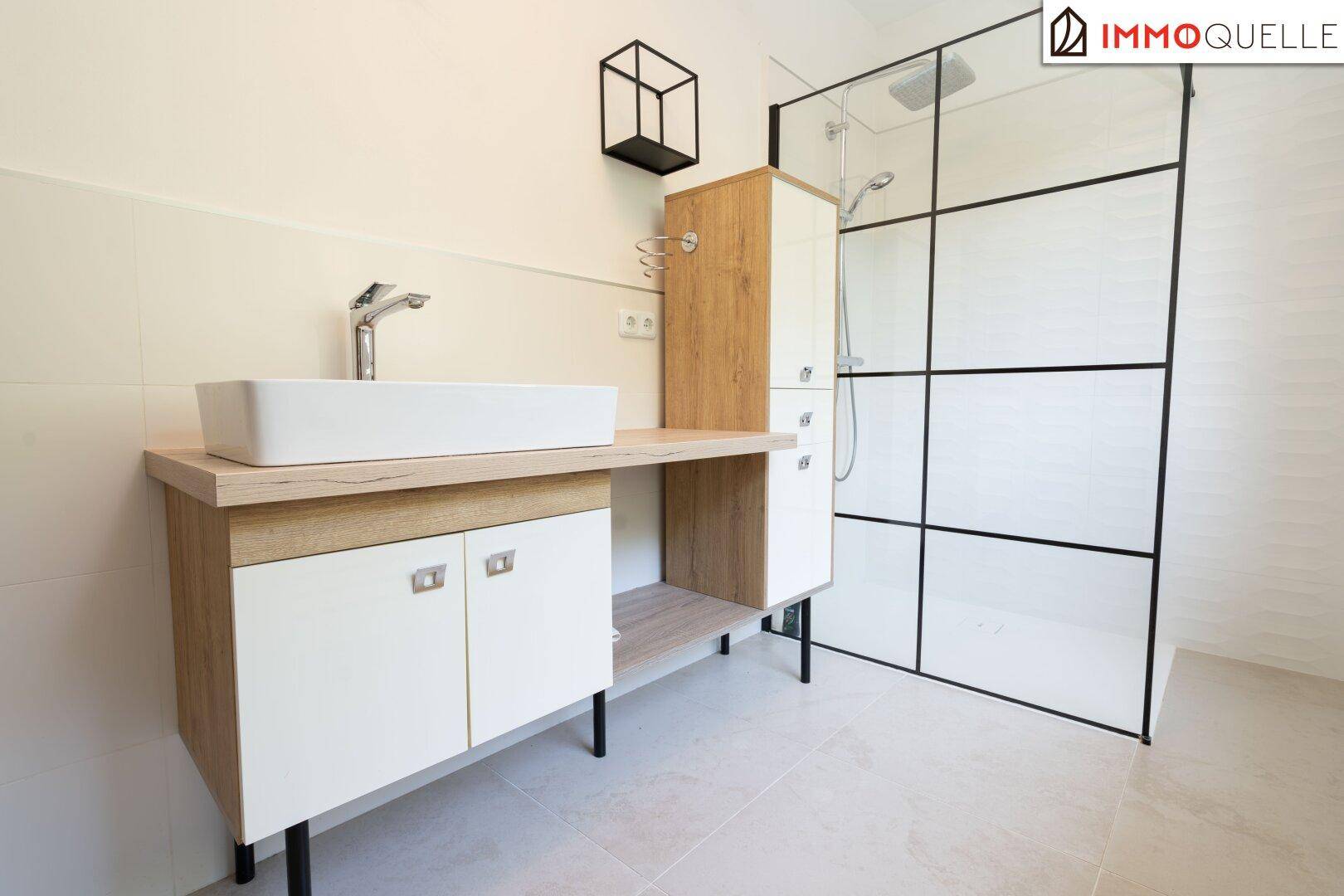 Stilvolles Badezimmer mit begehbarer Dusche und modernem Waschtisch mit Einzelwaschbecken.
