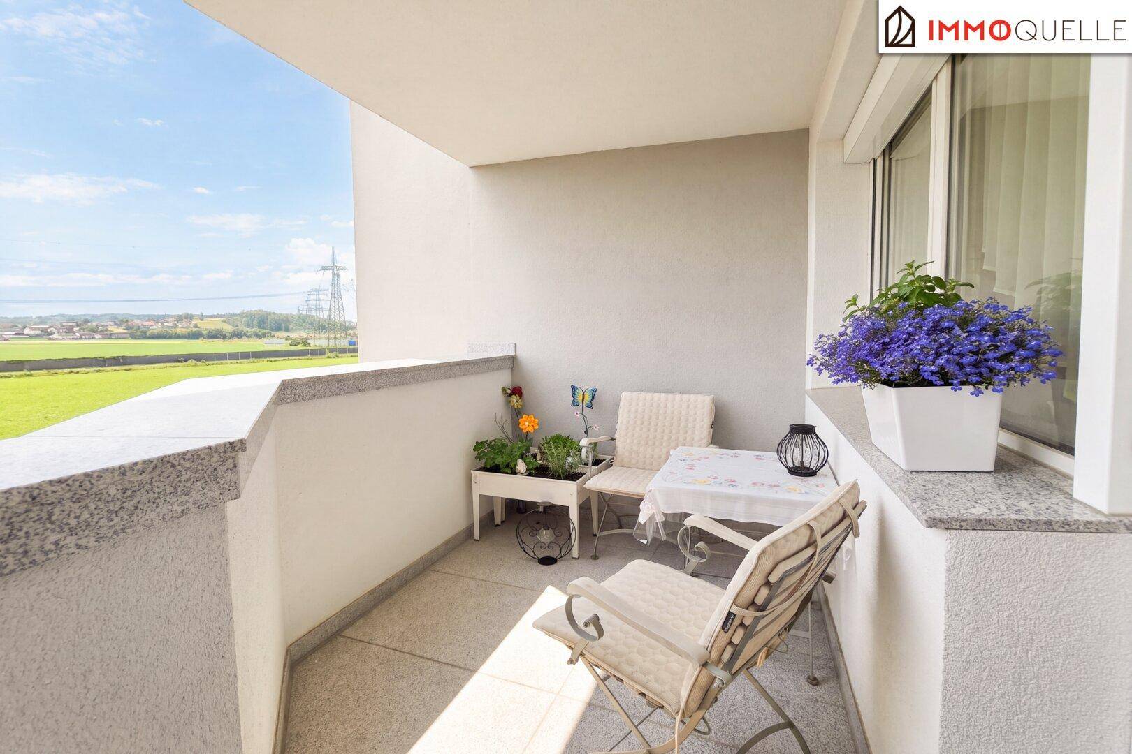 Möblierter Balkon mit Sitzgelegenheiten und Blick auf die umliegende Landschaft.